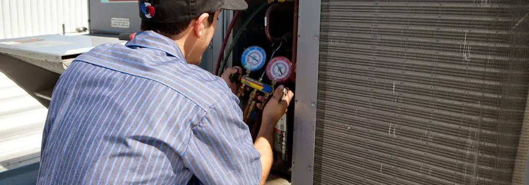 HVAC technician servicing a condenser unit in South Heidelberg
